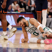 Jayson Tatum winces in pain on the ground after being injured against the New York Knicks